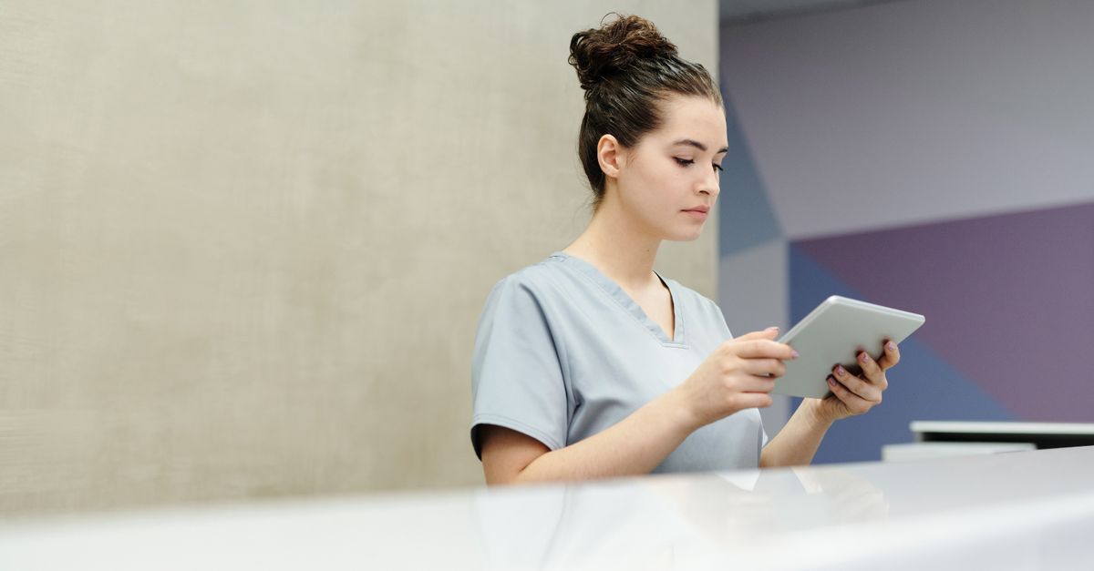 Recepcionista de clínica atendendo pelo computador