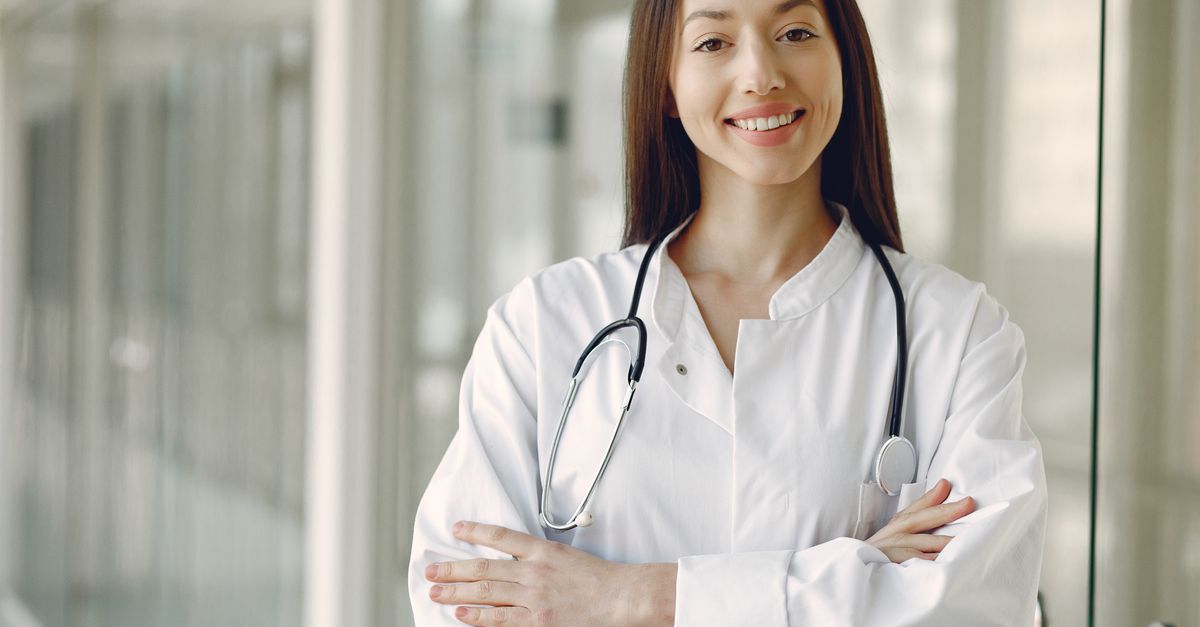 Médica sorrindo no corredor de uma clínica